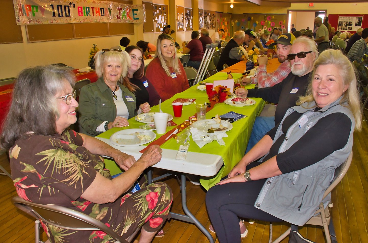 a group of people sitting at a table with plates of food