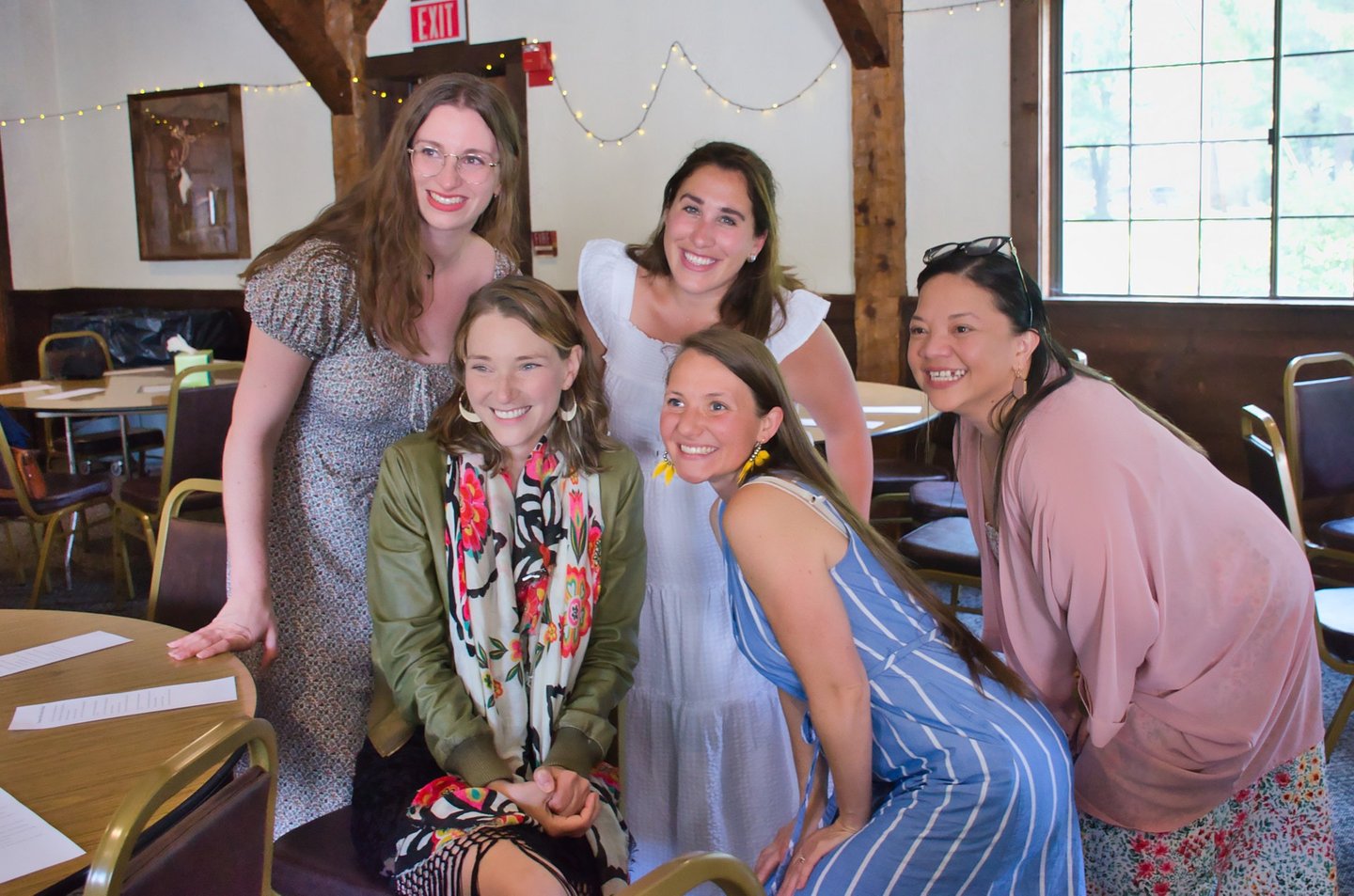 a group of women standing and sitting around a table