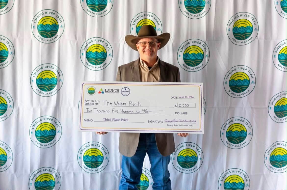 James Walker holding a check after winning The Singing River Trail Launch Tank