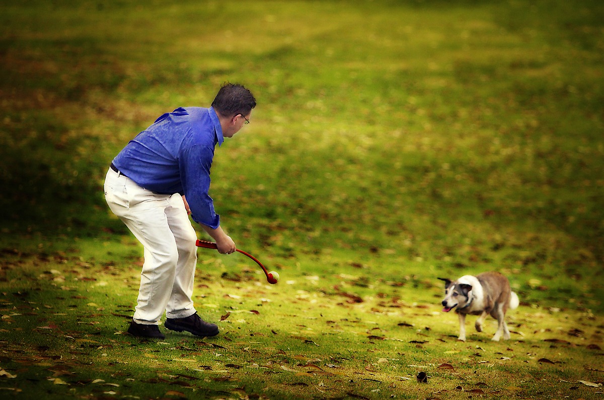 A man plays with his dog in a pet photo by Geoff Fisher