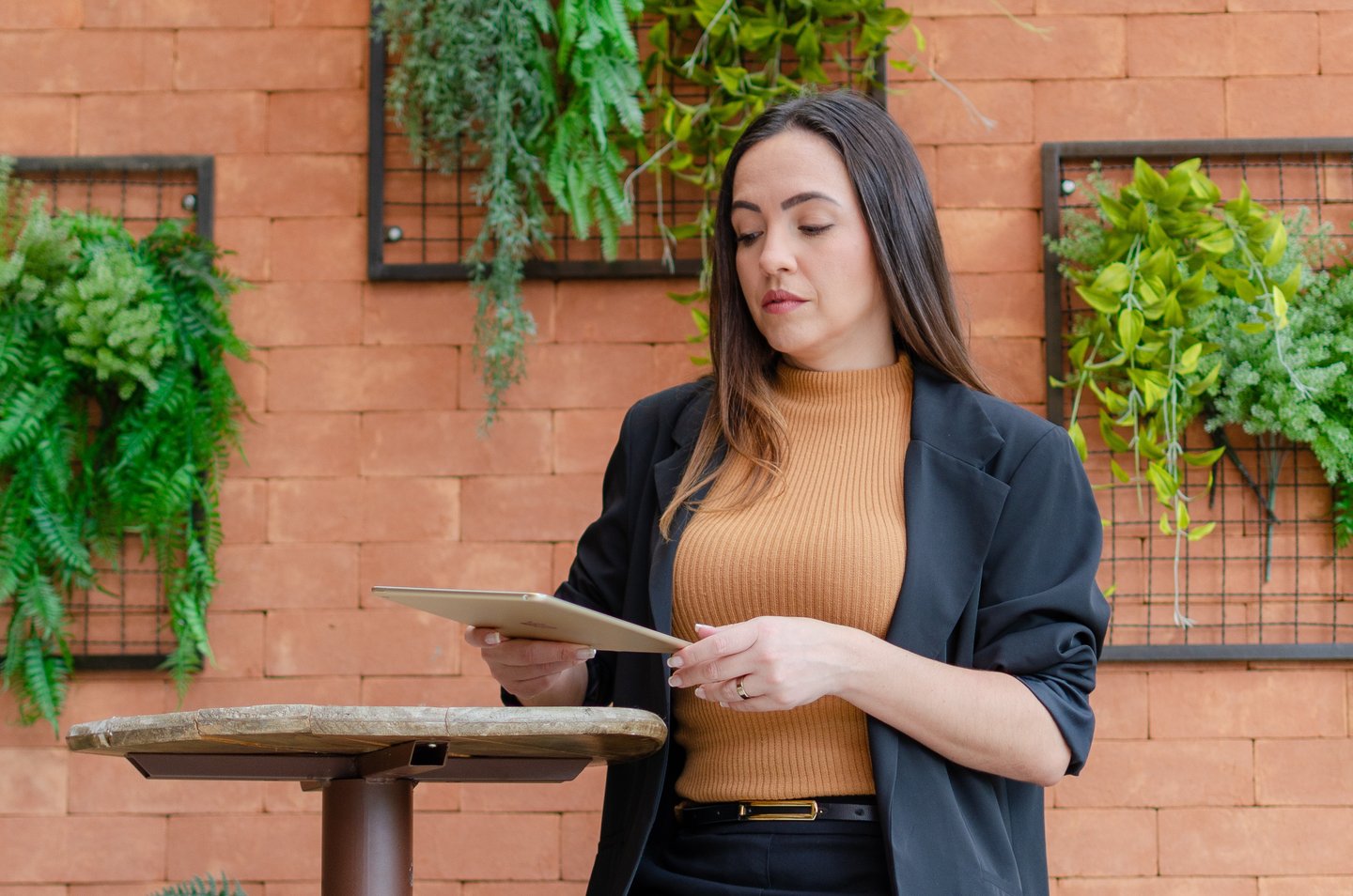 uma mulher de jaqueta preta e um tablet