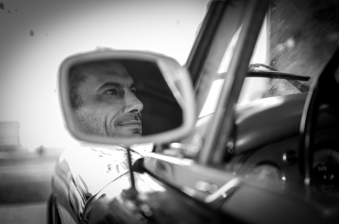 a man in a car mirror and a car mirror