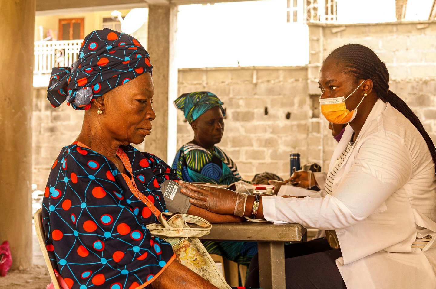 Health professional taking a woman's blood pressure.