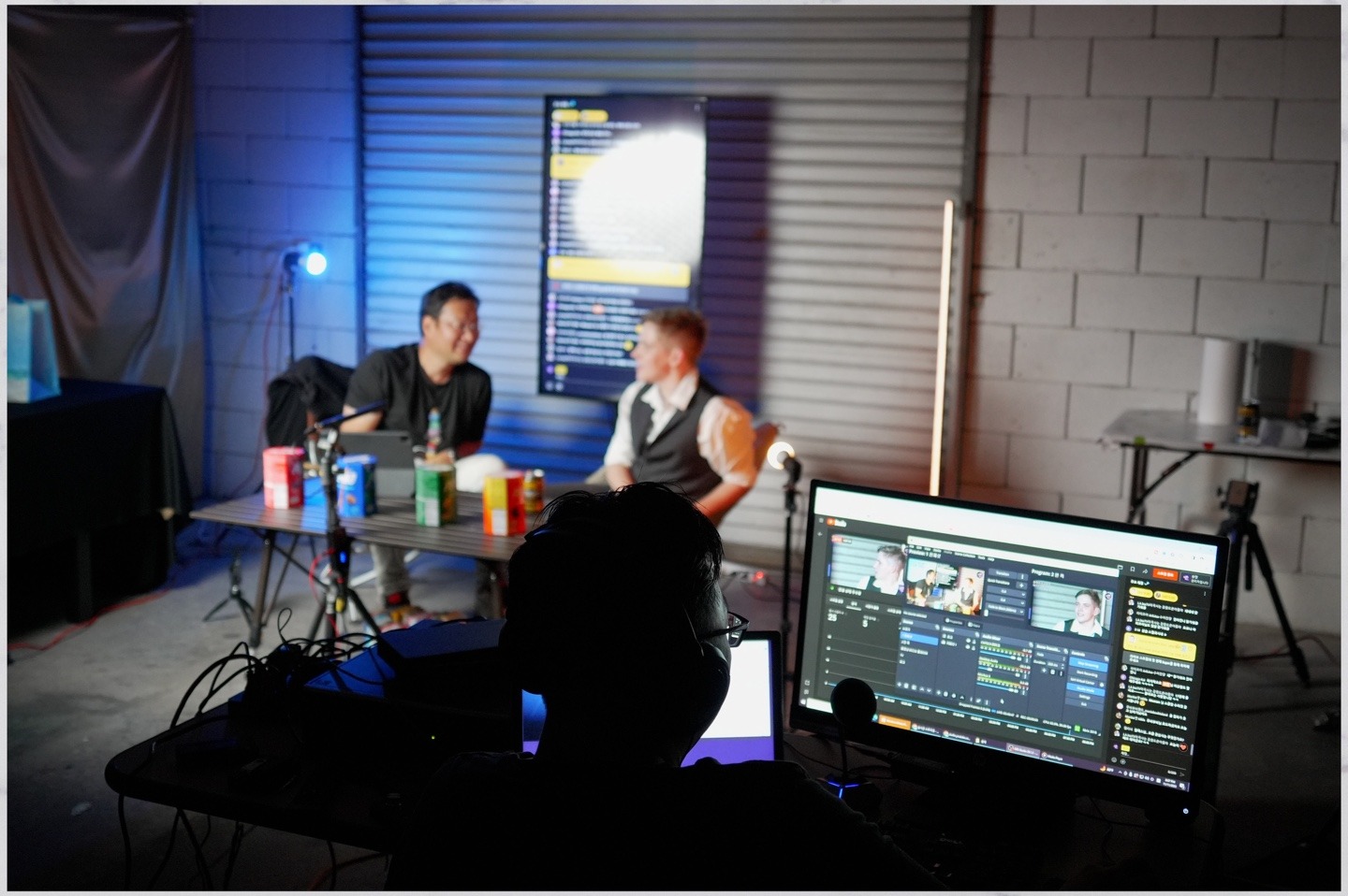 two people sitting at a table with a computer screen