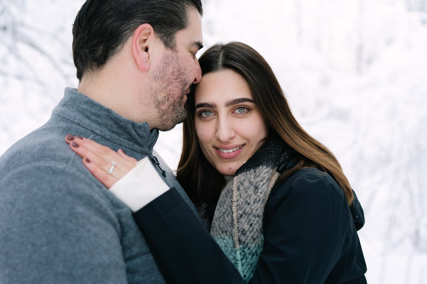 a man and woman standing in the snow