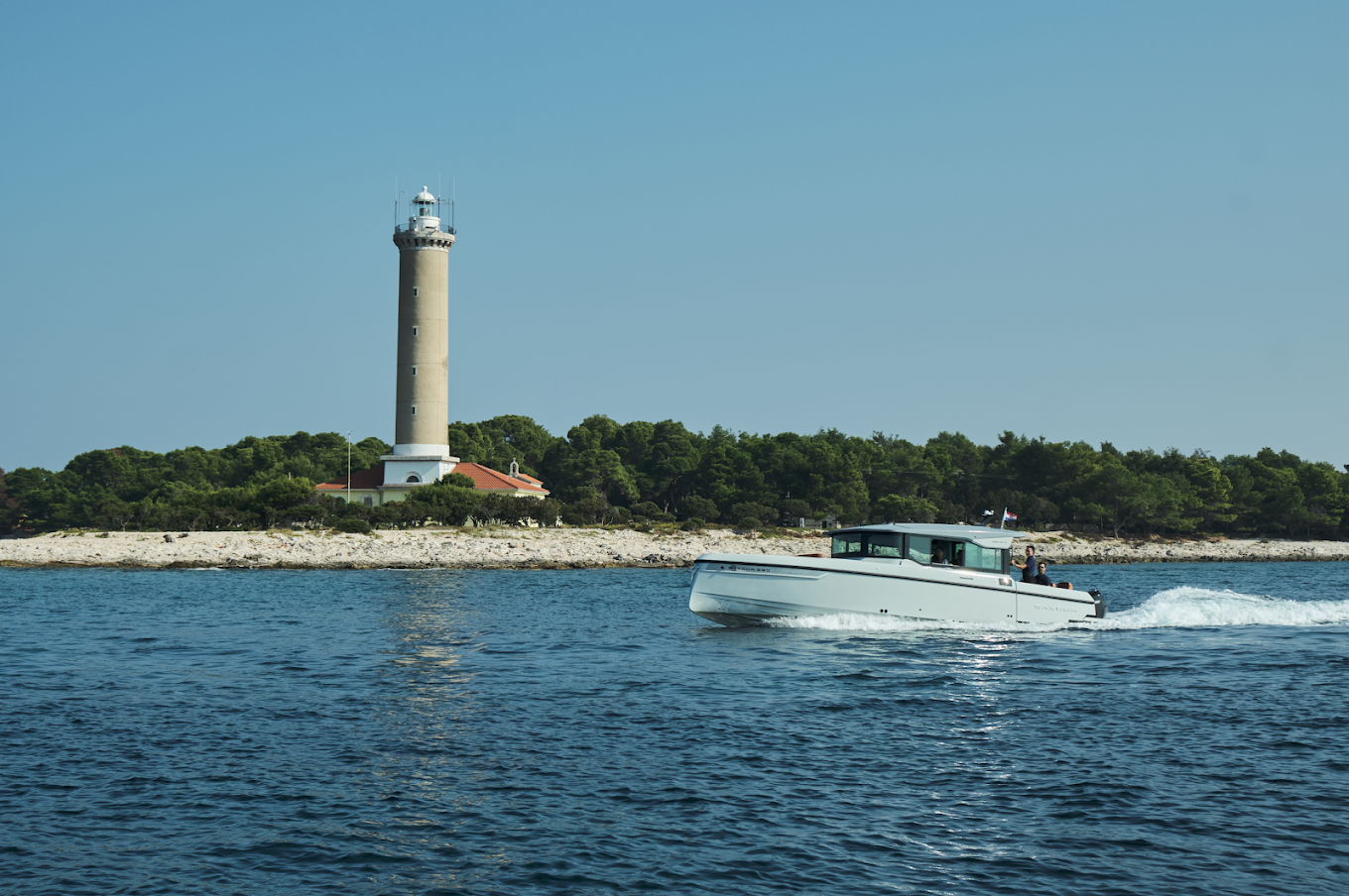 Just enjoy boat cruising the waves, passing by a lighthouse on the shore.
