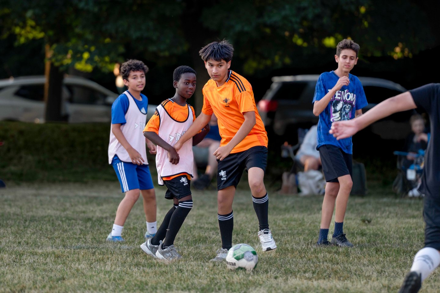 Youth soccer players MVB FC competing for a ball during a grass field match in Mississauga