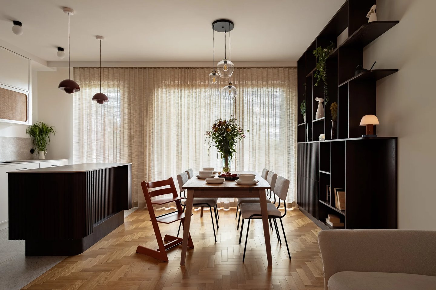 Szeroki kadr: otwarta strefa dzienna, jadalnia i naturalny parkiet.