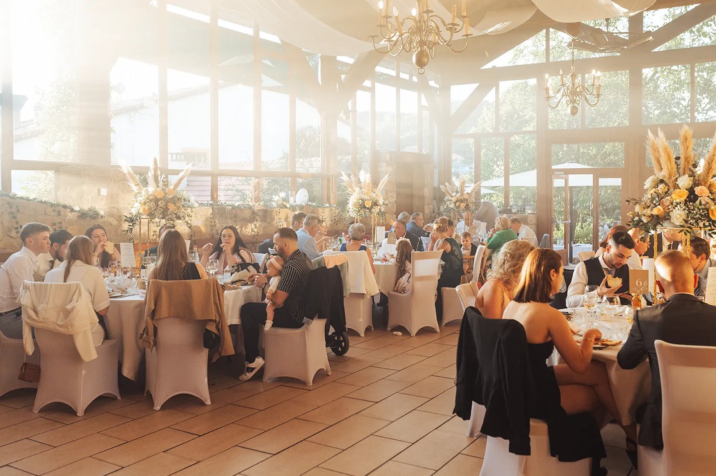 Salle de réception avec une lumière de coucher de soleil durant un mariage à l'Auberge de la Klauss