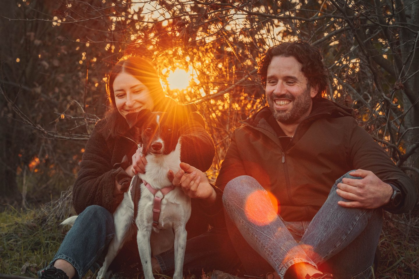 ragazza e ragazzo con cane al tramonto