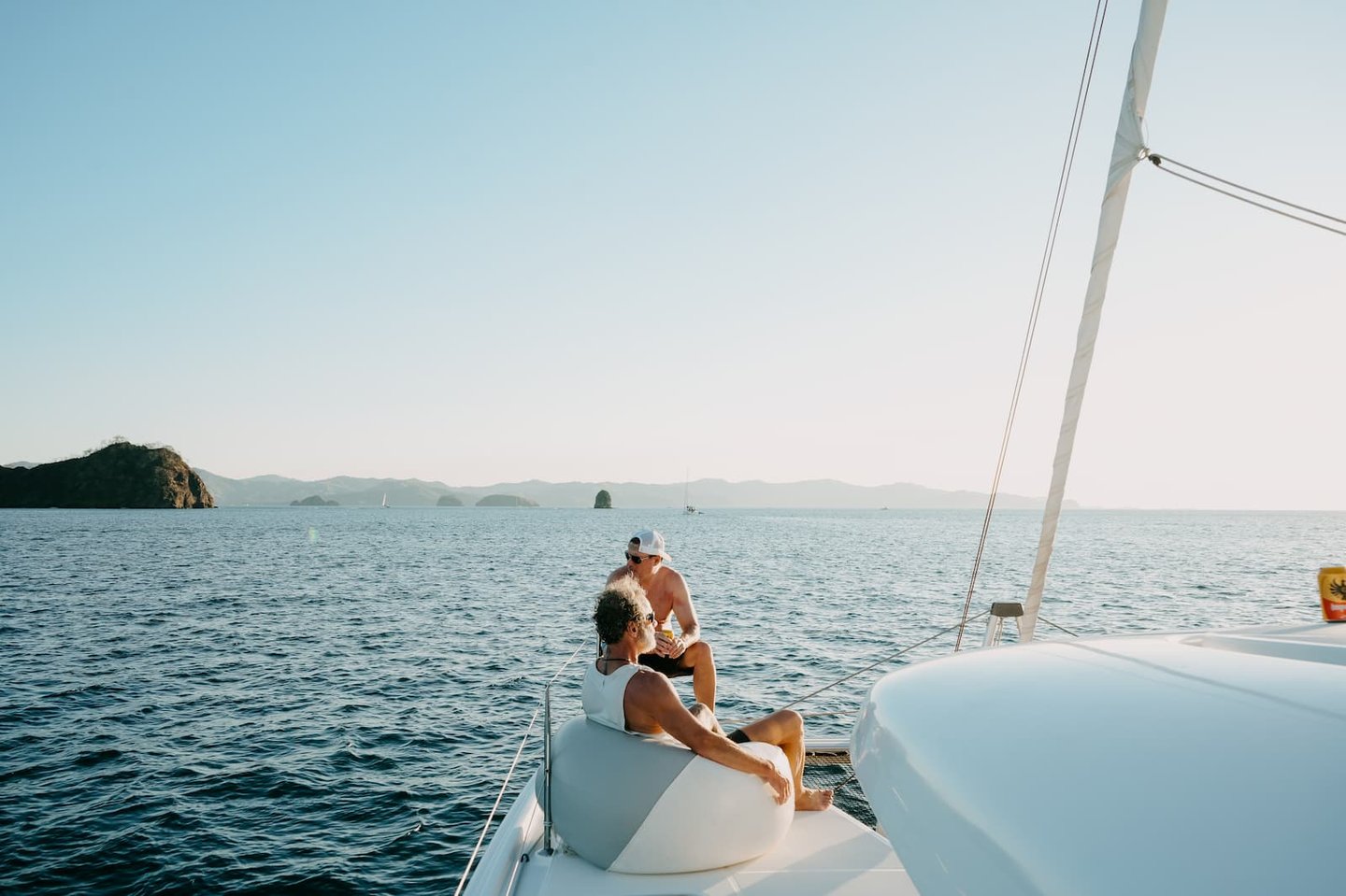 Couple relaxing on the bow of private luxury catamaran in Guanacaste, Costa Rica
