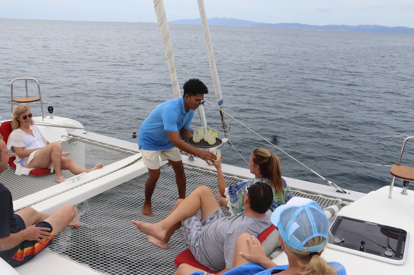 Professional crew providing personalized service to guests on luxury catamaran tour in Costa Rica