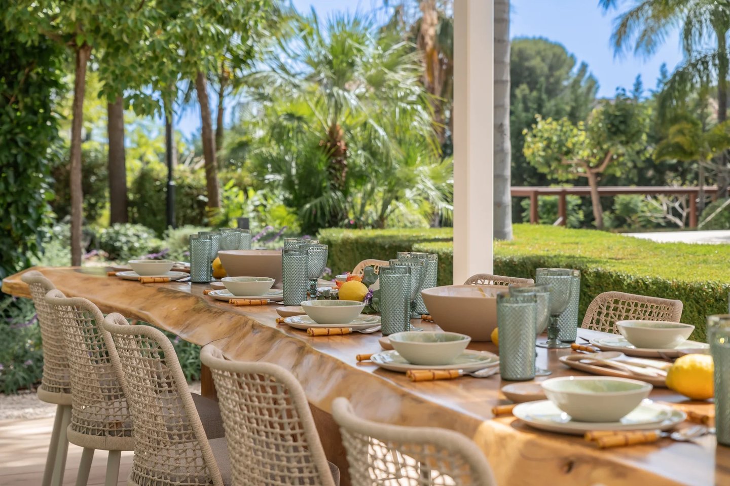 Outdoor dining table set within tropical gardens