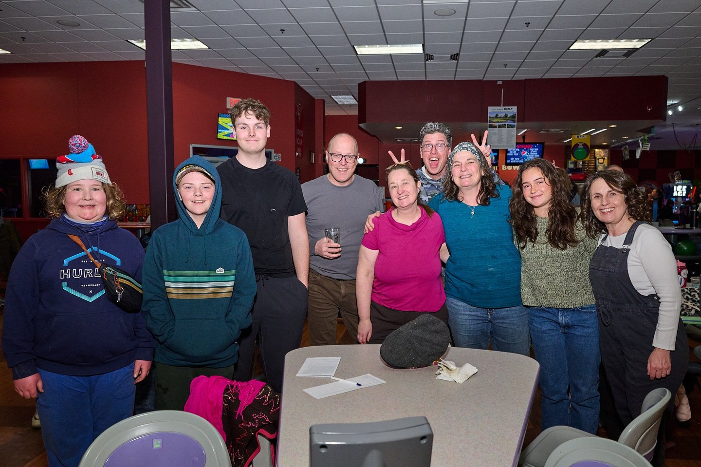 a group of people standing around a table in a bowling alley