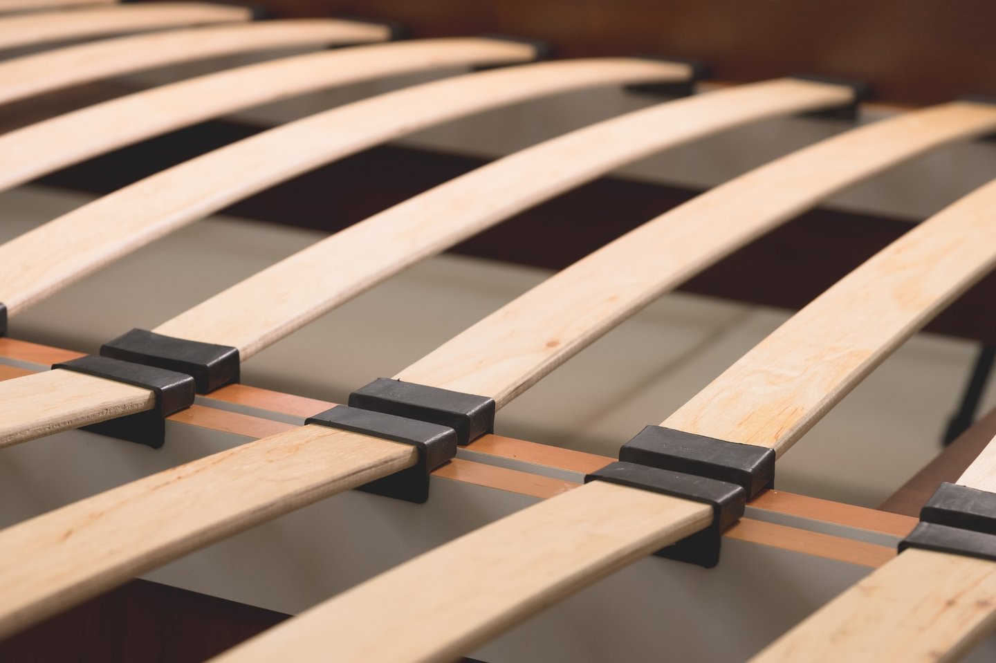  flexible wooden bed slats with black plastic holders for ergonomic mattress support.