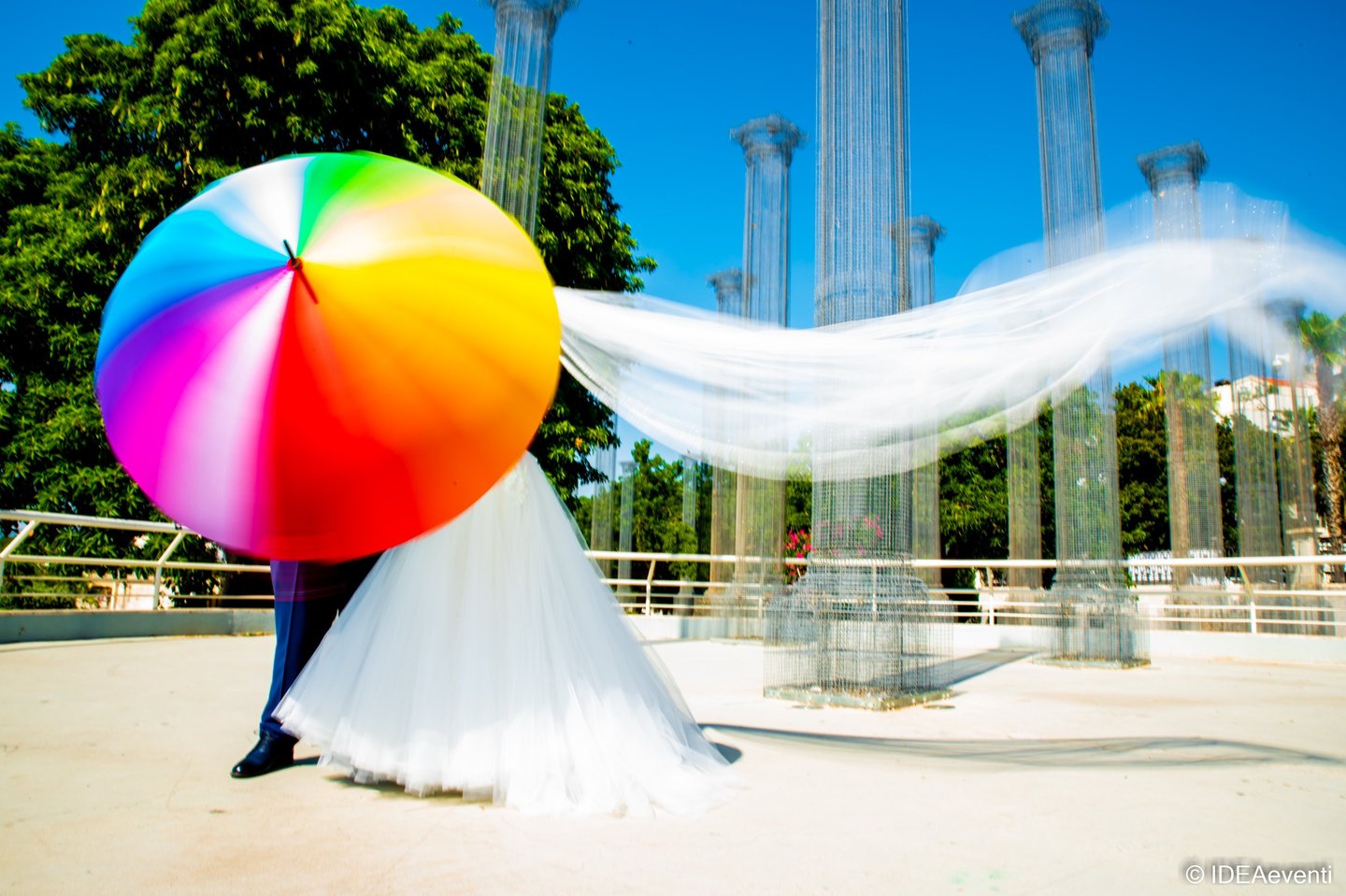 sposi che si divertono con un coloratissimo ombrello