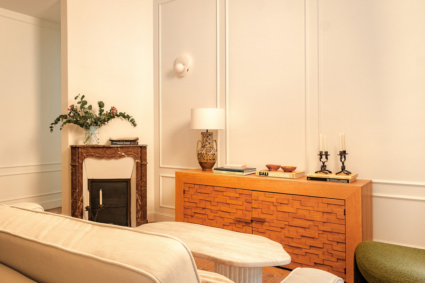 Salon haussmannien rénové à Paris avec cheminée ancienne et buffet en bois sculpté, vintage