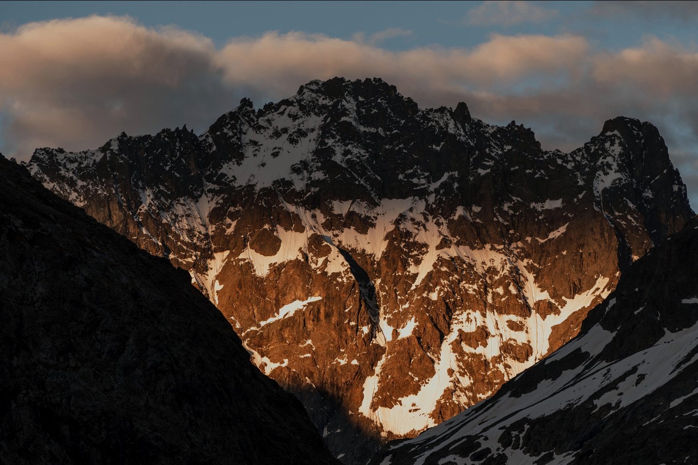 Levé de soleil au travers des nuages sur la Roche d'Alvau (Ecrins)