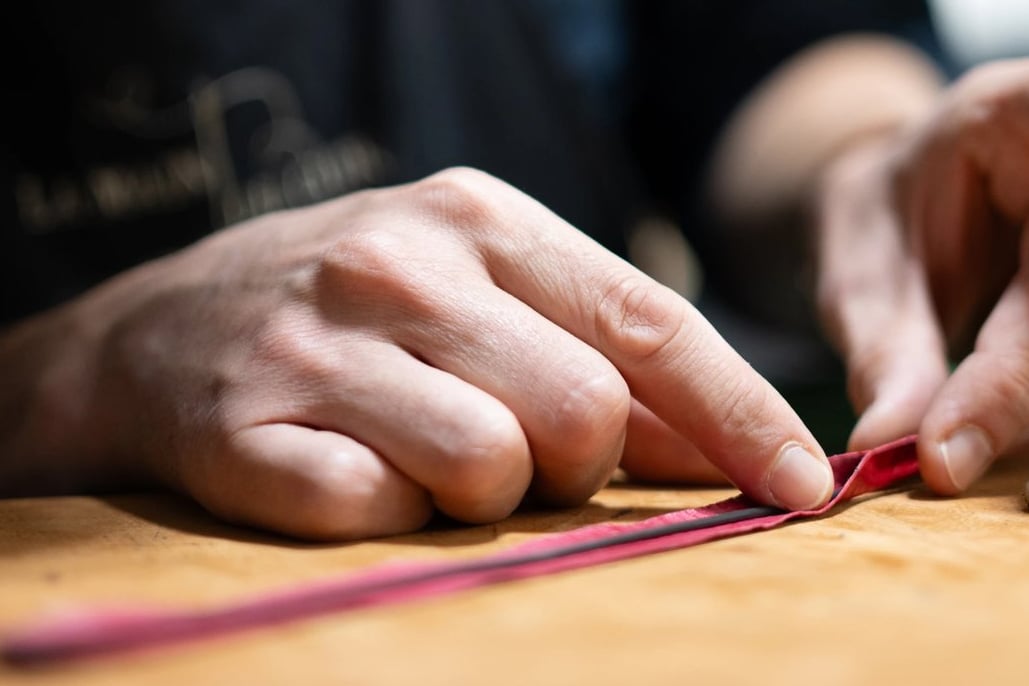 Le maroquinier assemble un jonc en cuir à la main