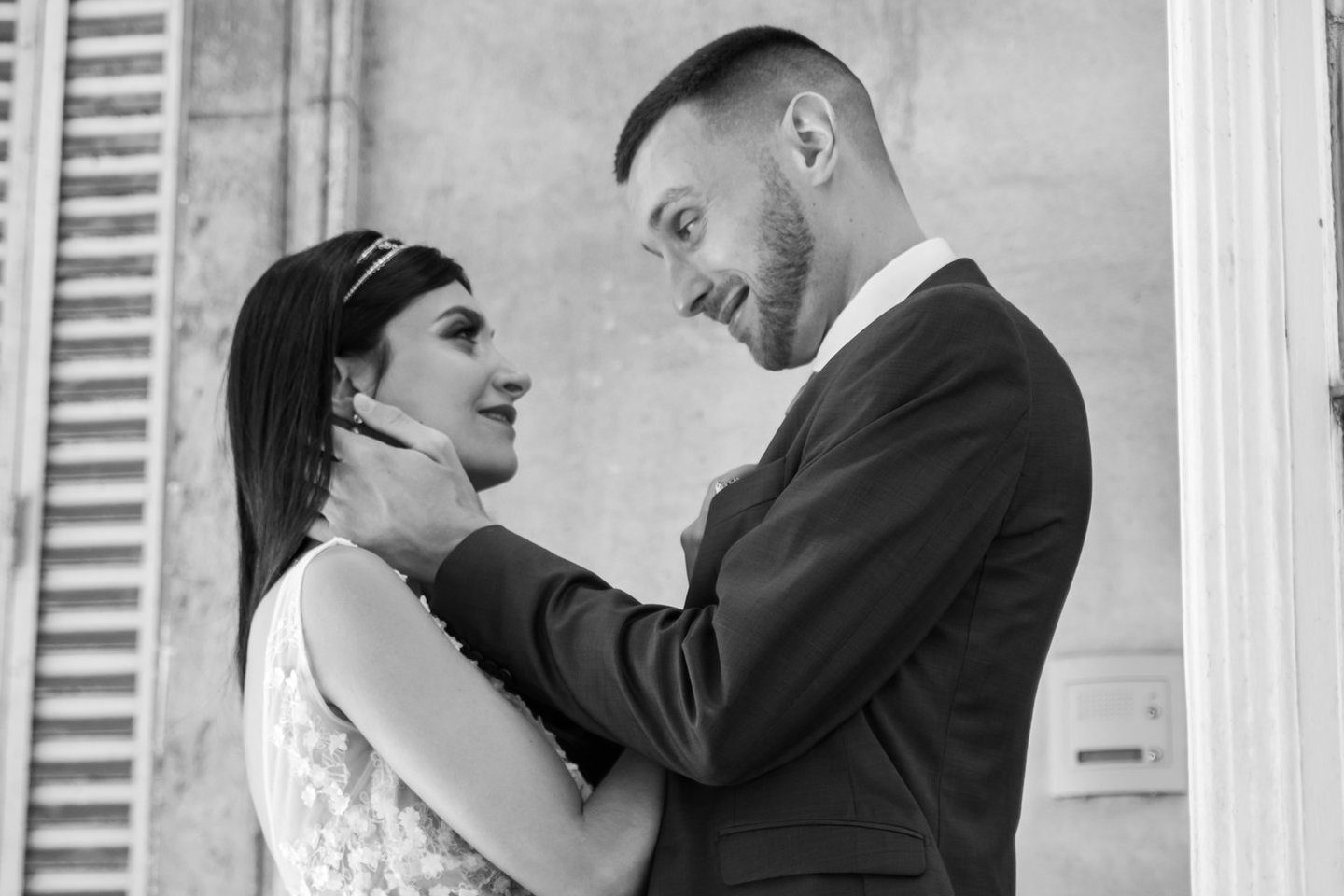 a bride and groom standing on a balcony railing