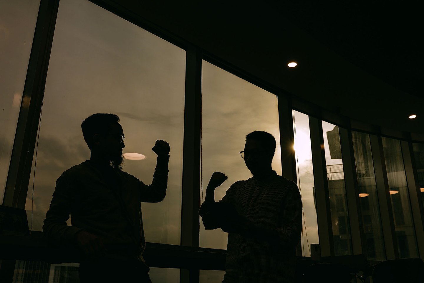 two men standing in front of a window