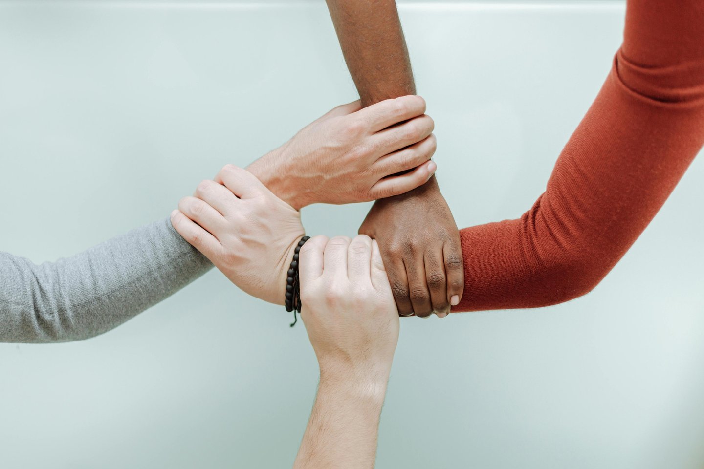 a group of people holding hands together suggesting harmony and inclusion