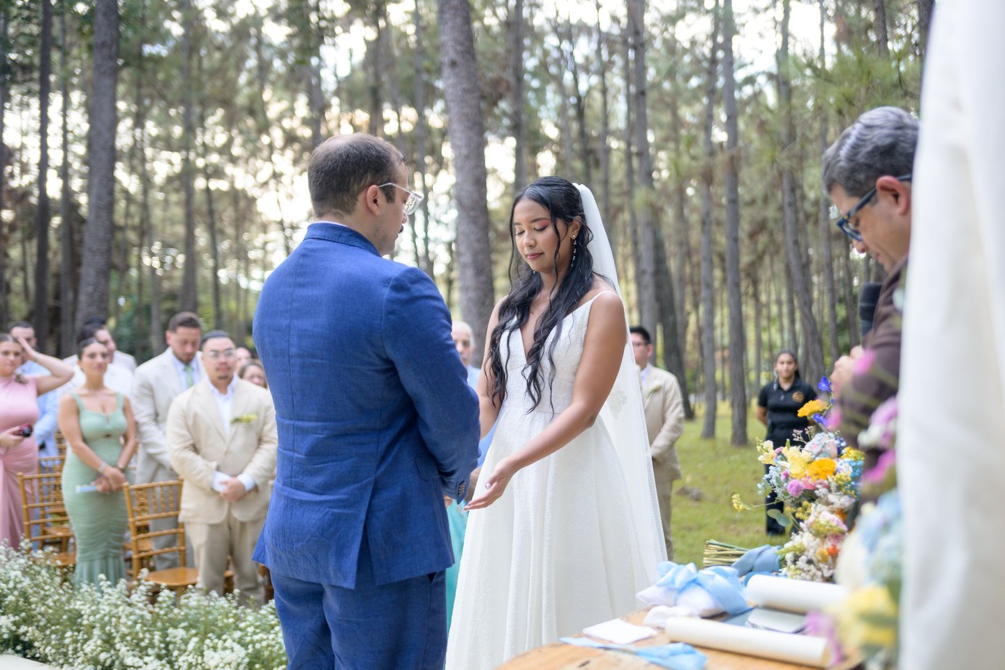 Pareja tomándose las manos, en ceremonia en medio del bosque. Foto: Victor King