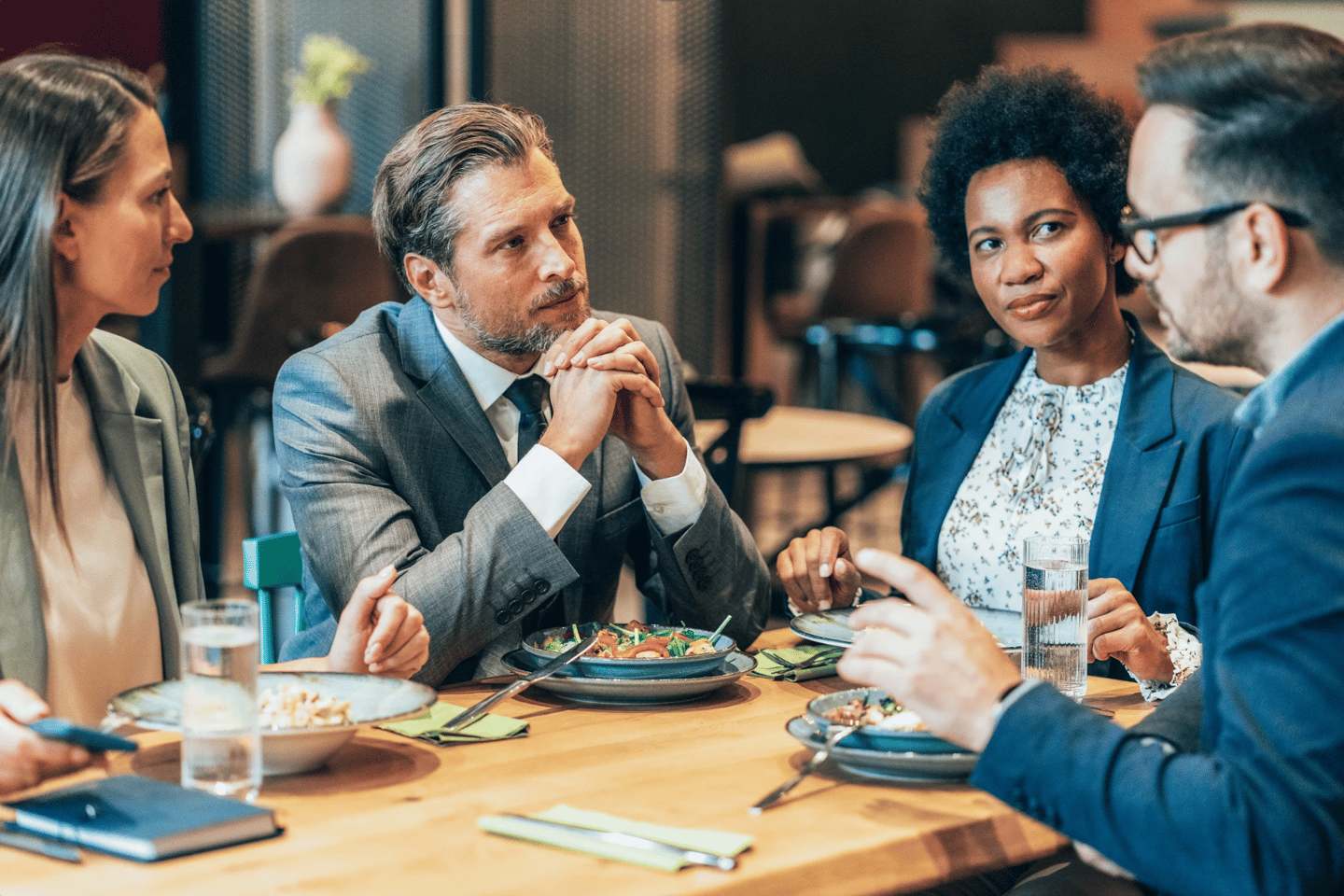 a group of people sitting at a table with food