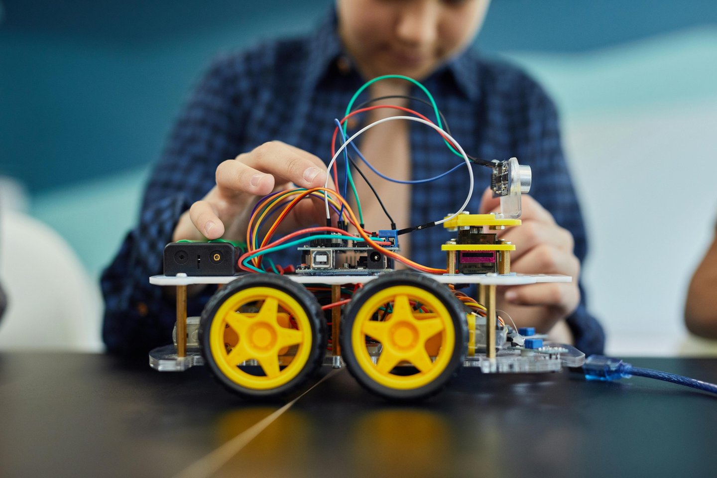 a girl is holding a arduino car