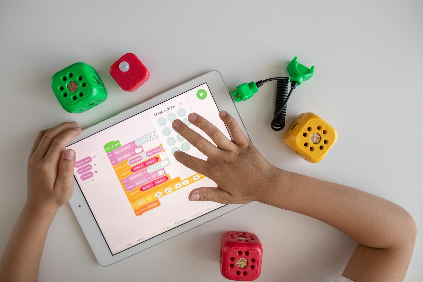 a child's hands on a tablet with dice