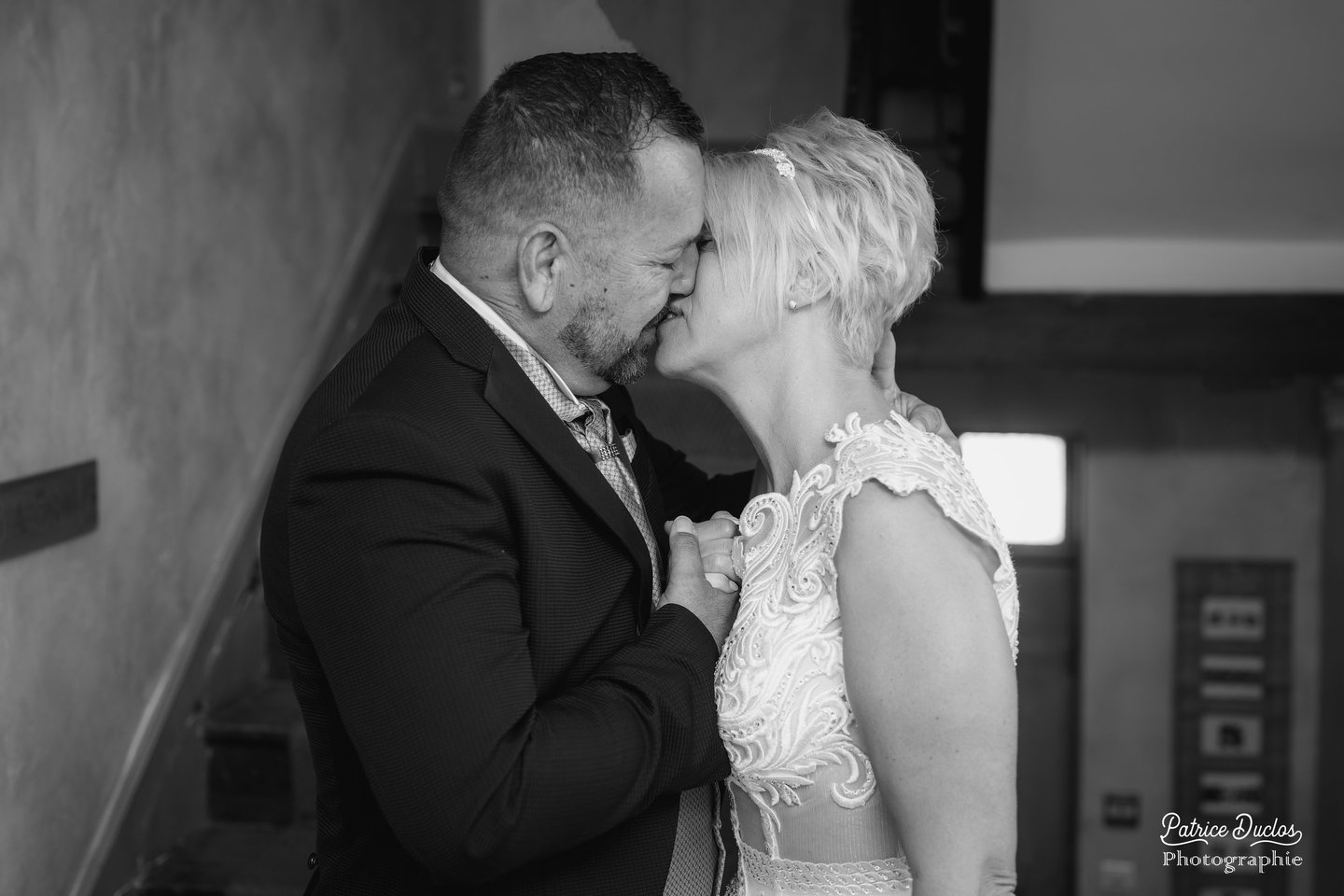 a bride and groom kissing on the stairs of a staircase