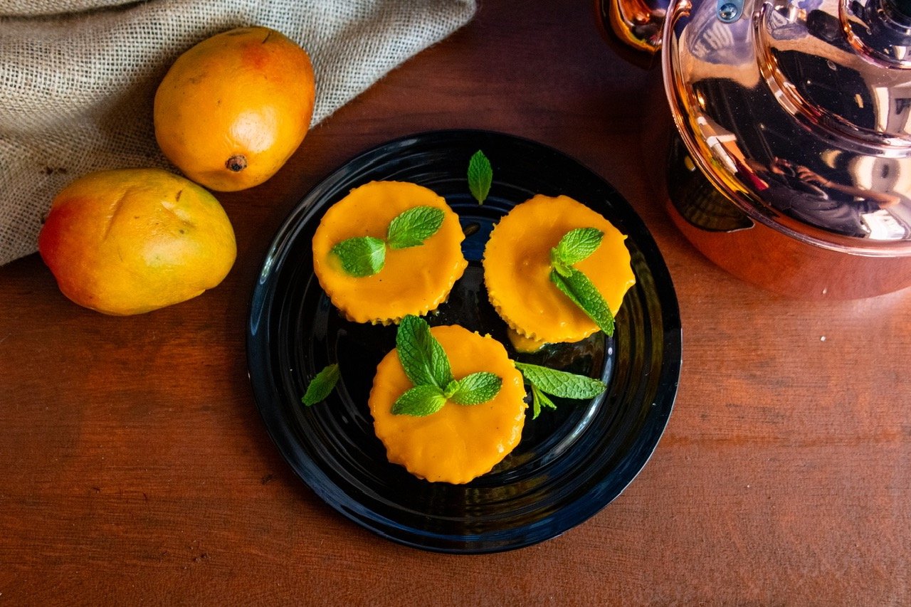 Mango lassi cheescake varnished with a mint leaf on top- plated