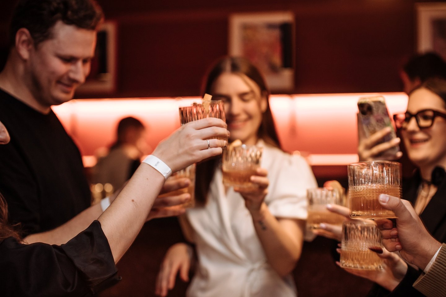 a group of people holding glasses and drinking wine