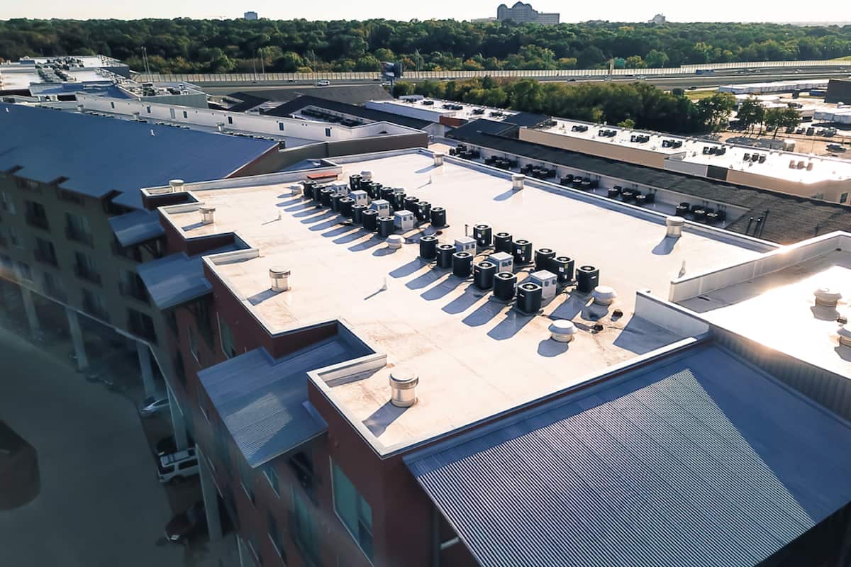 view of rooftop of building with many hvac condenser units in a row