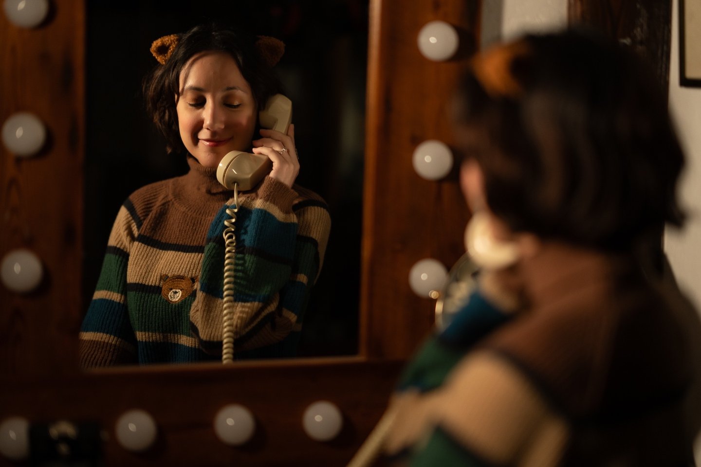 Maria in a sweater with a teddy bear on her phone