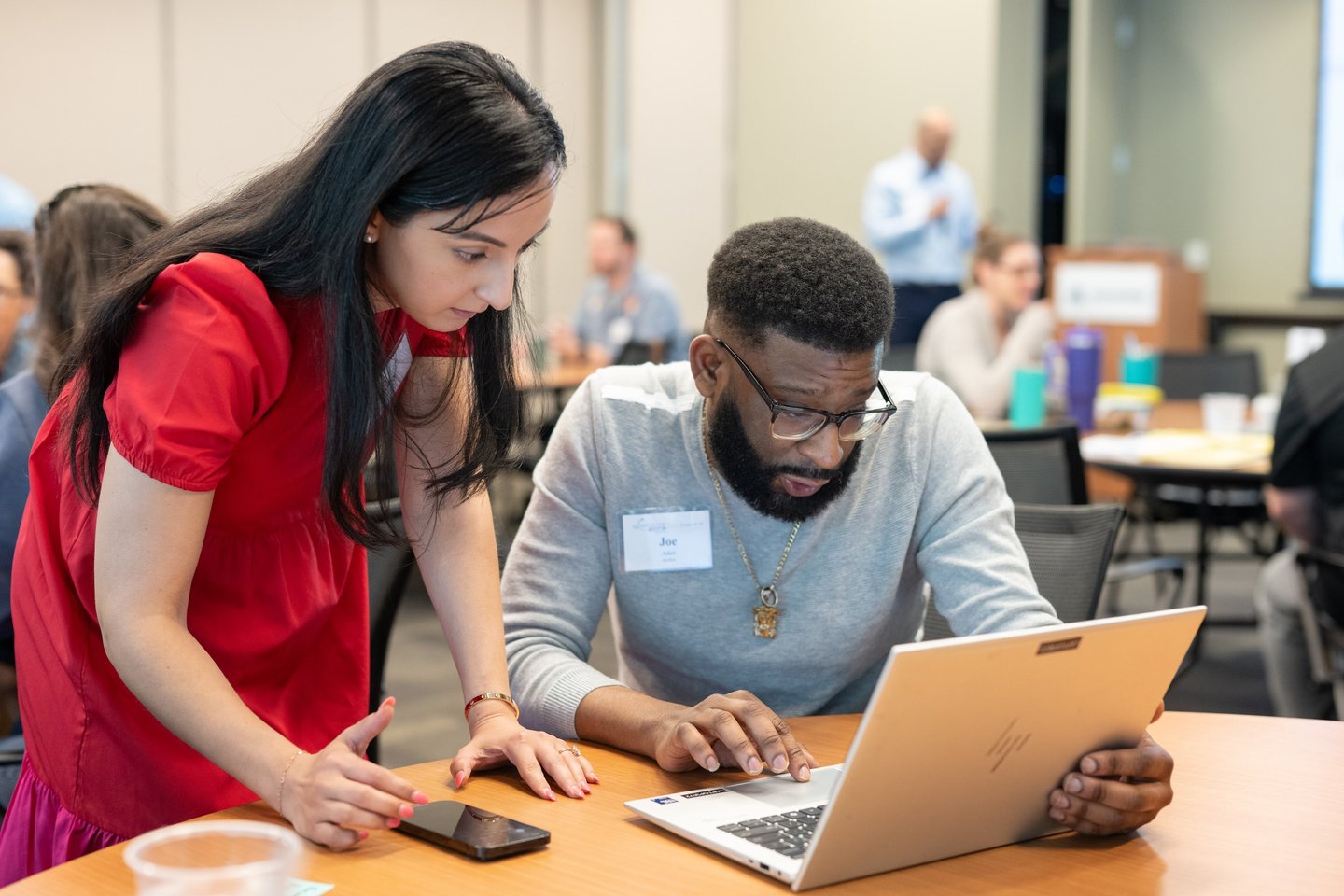 Leadership Austin participants focus intently on a laptop screen.