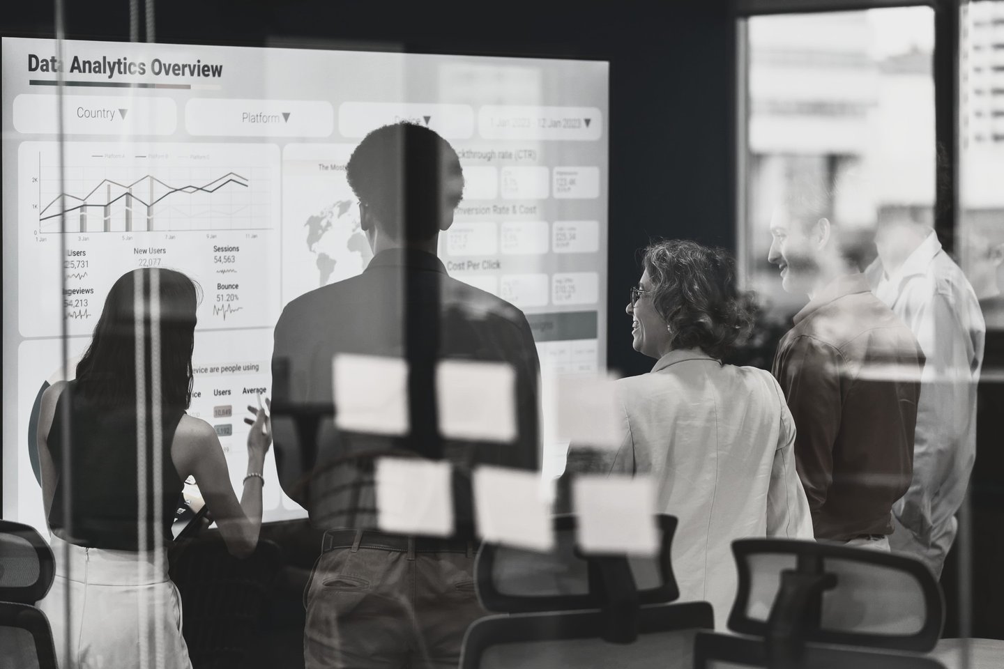 a group of people standing in front of a white board looking at slide titled Data Analytics Overview