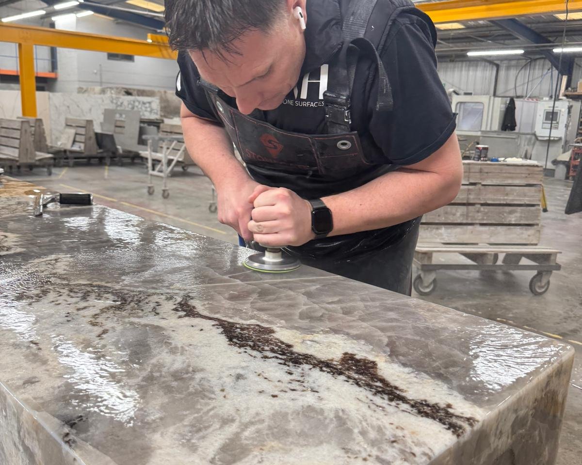 RH Stone Surfaces fabricator polishing a granite kitchen worktop in our North East factory