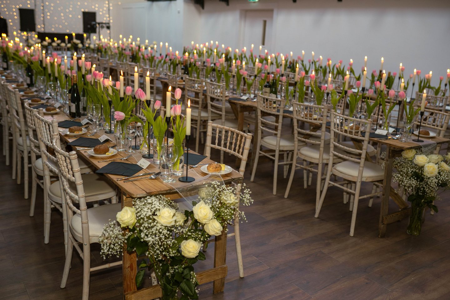 a long table with candles and flowers in a room