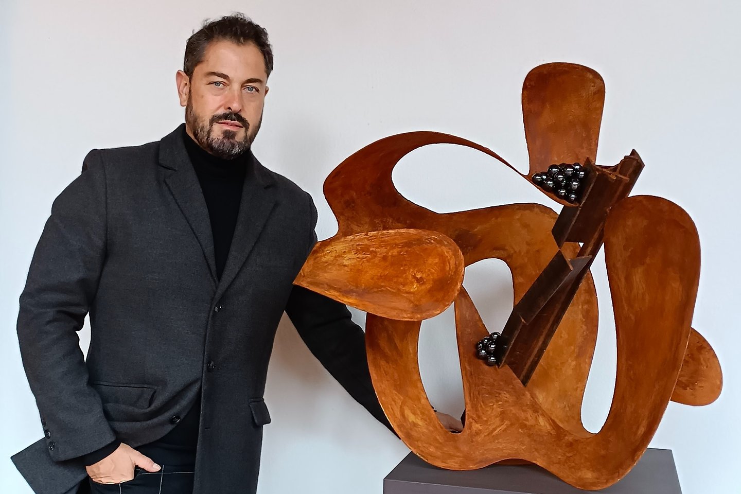 Pedro Alonso, artista y escultor contemporáneo, junto a una obra en su estudio.