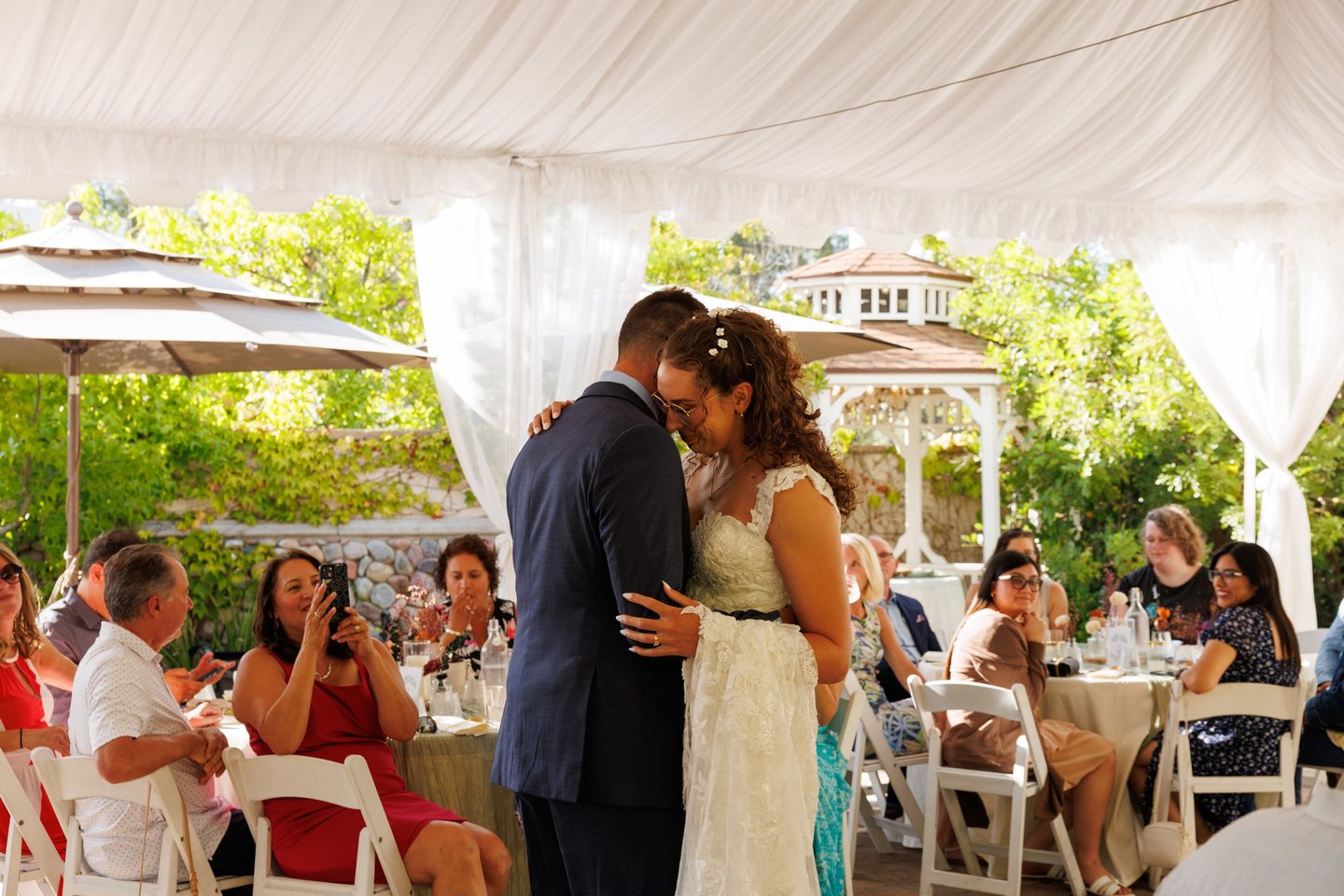 a bride and groom kissing in a tent