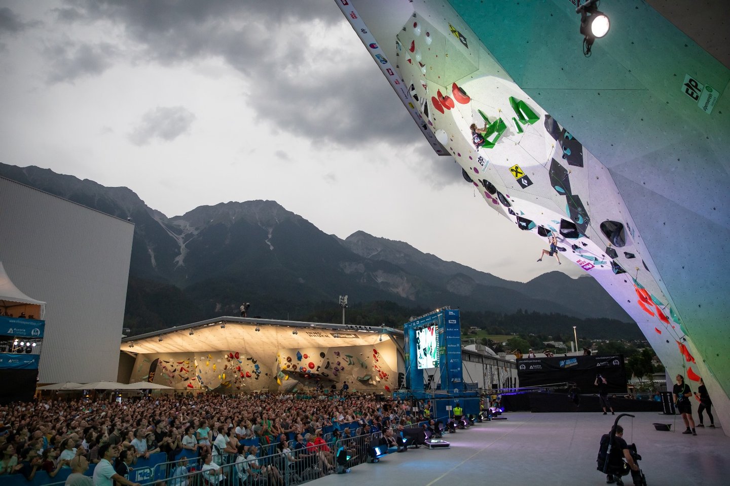 a climber on a climbing wall with a crowd of people watching