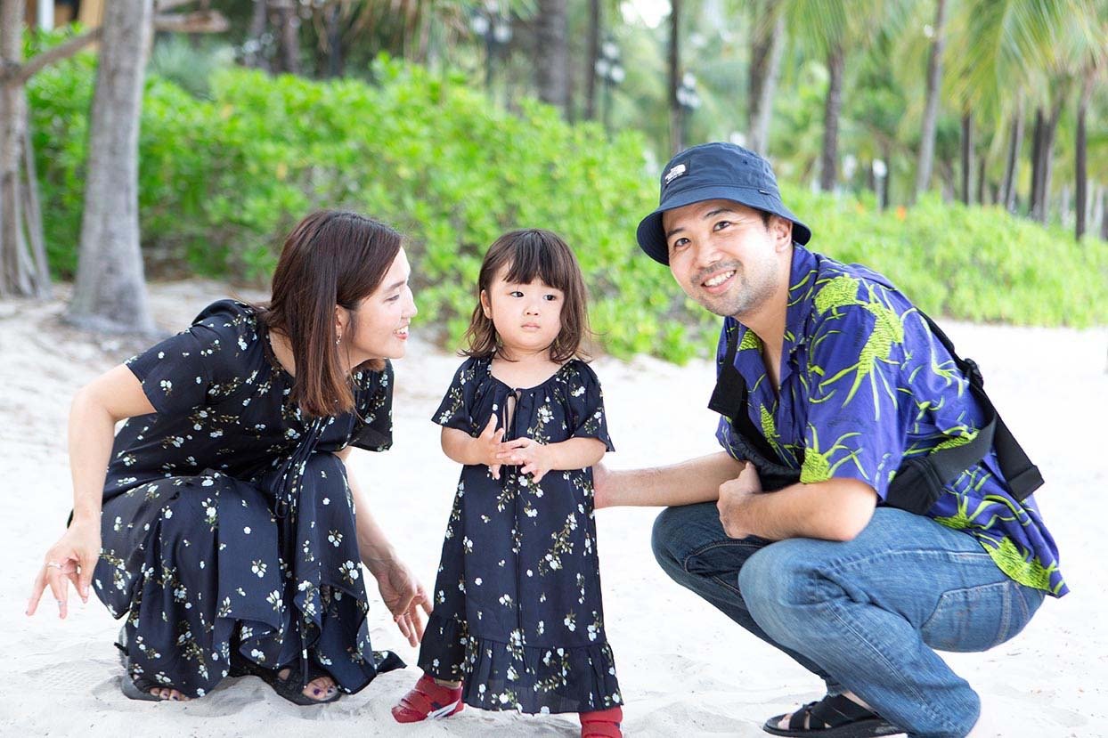 Family posing with child on Khem Beach in Phu Quoc