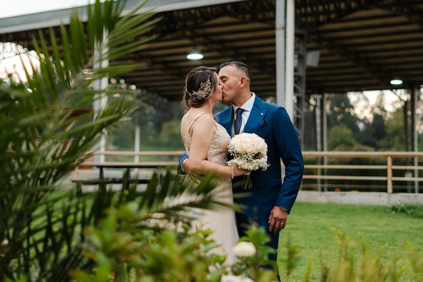 Fotografía de bodas en Quito, Ecuador, pareja de recién casados dándose un beso en un paisaje verde
