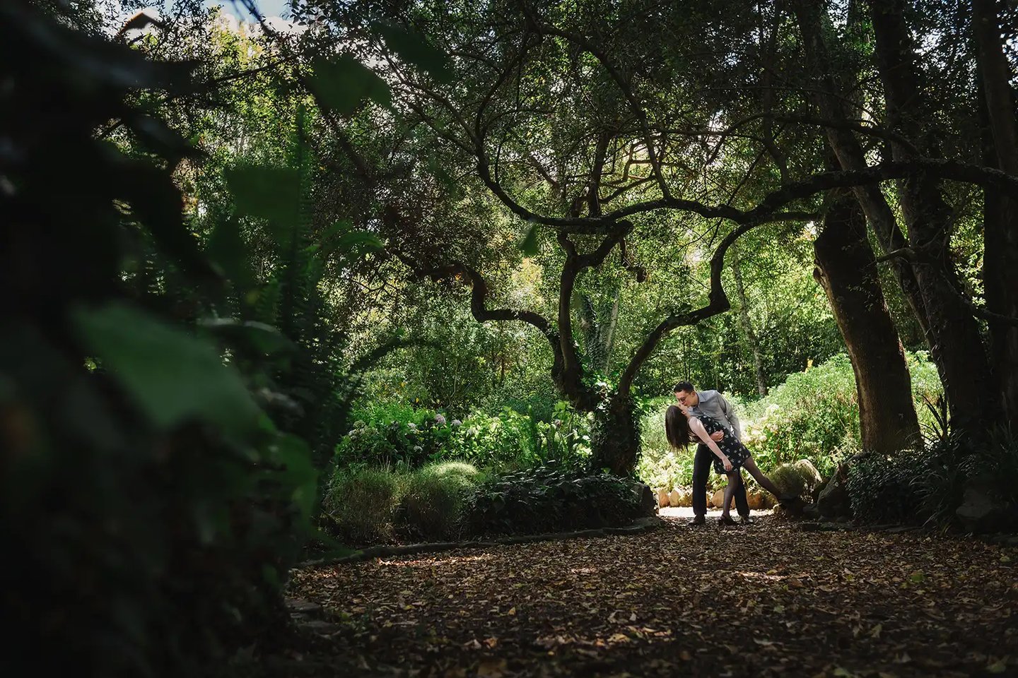 Sesión de fotos de compromiso una pedida de mano de hombre dando beso a su novia en medio del bosque en Quito antes de boda