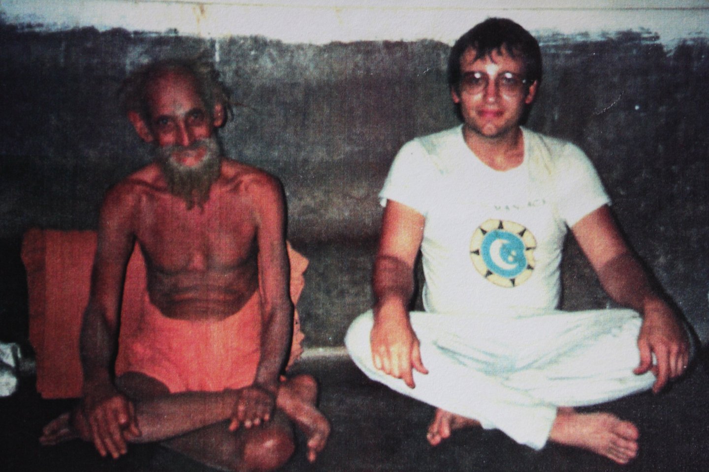 a man sitting on the floor with a beardless man