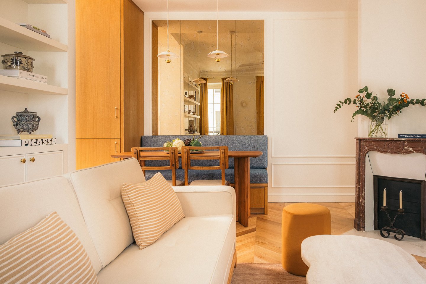 Vue du salon et coin repas avec miroir sur mesure vieilli dans un appartement haussmannien à Paris