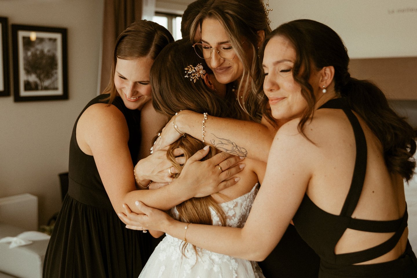 Quatre demoiselles d'honneur émotives qui enlacent une mariée