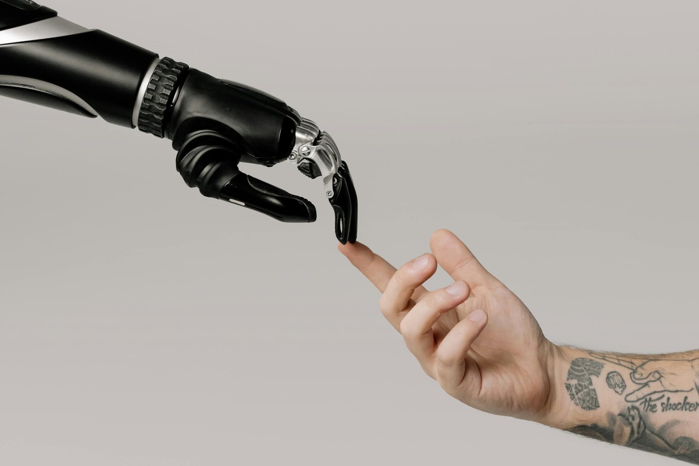 Human hand connecting with robotic hand representing collaboration between AI technology and thedigiwold.in 
