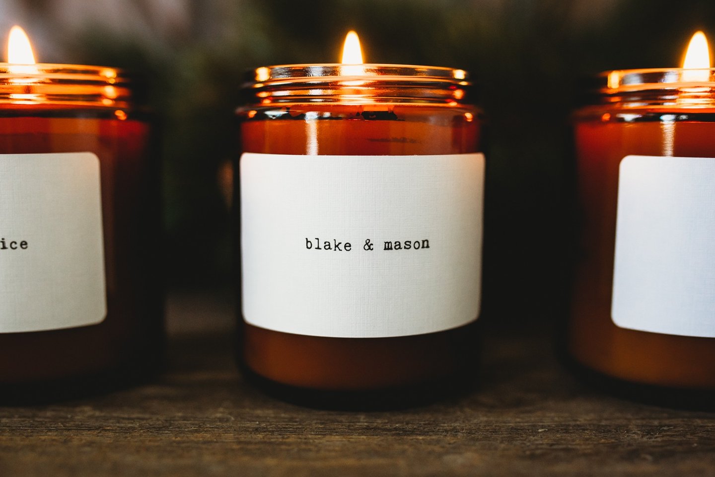 three candles with labels on them are sitting on a table